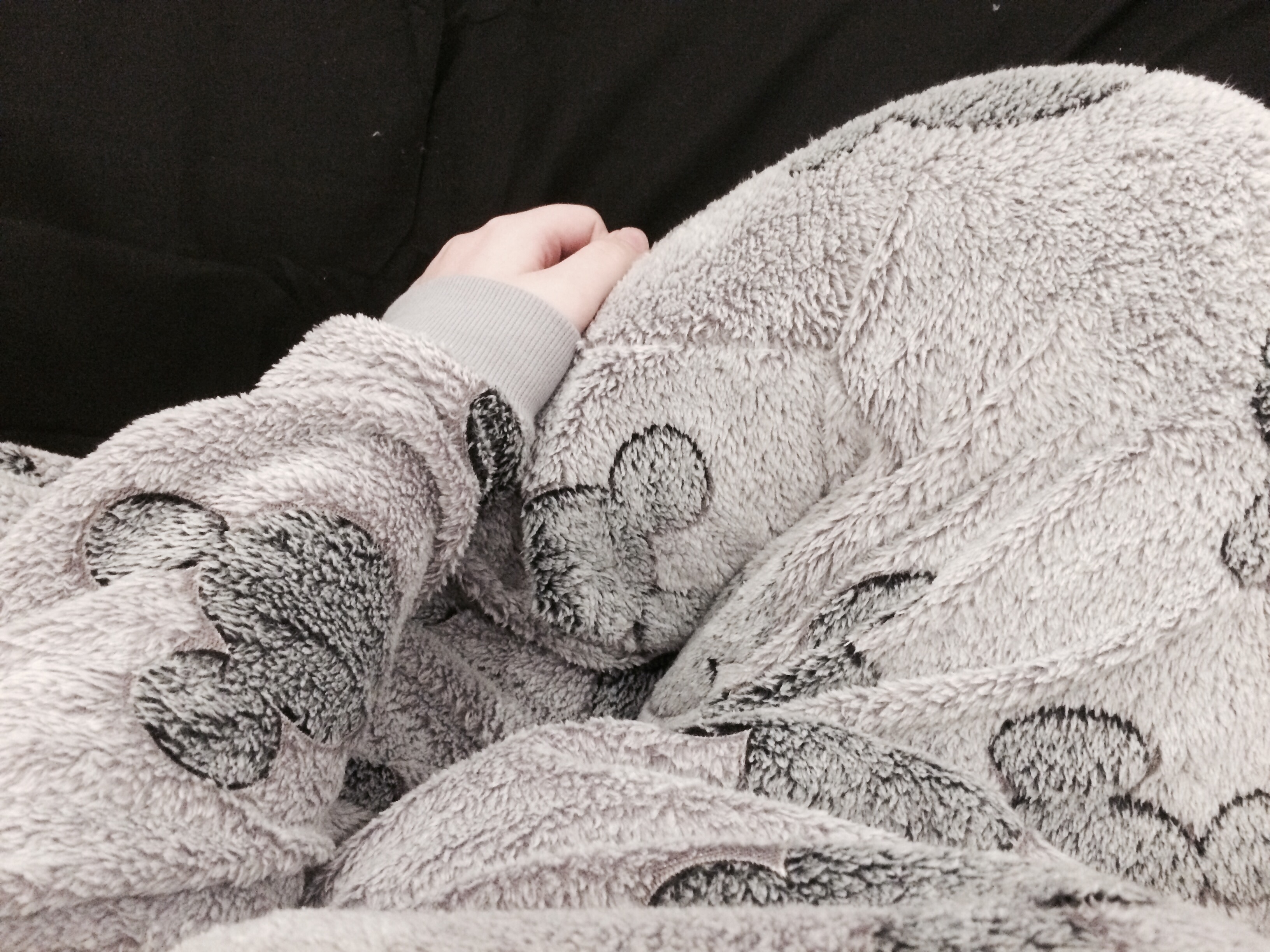 A photo of Tiegan Elise’s lower half cuddled up on the bed.